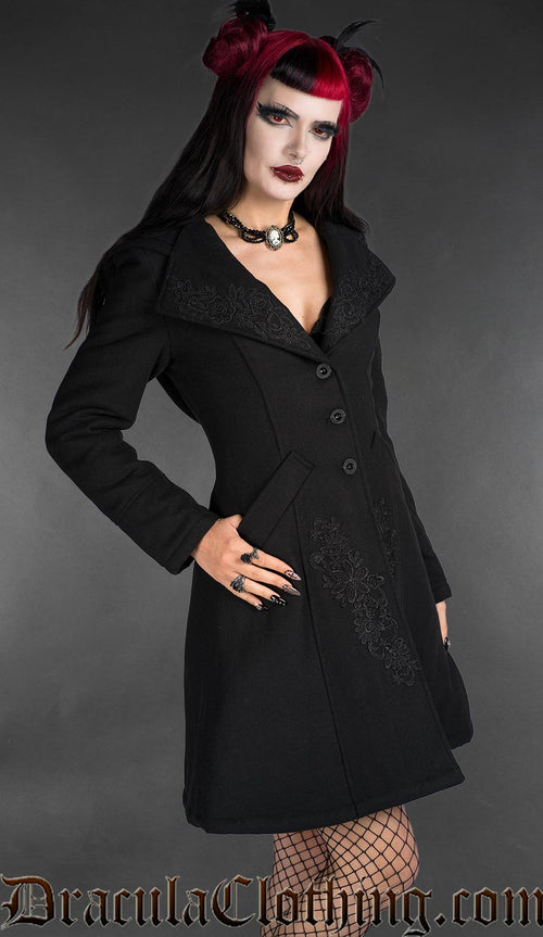 Black embroidered wool coat with fitted silhouette, button front, and decorative gothic detailing worn by model