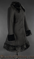 Side view of women's black knee length coat with black faux fur accents on collar cuffs adn hem