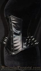 Women's black faux leather corsets with silver spike embellishments on the hips