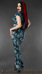 Back view of flared velvet pants in blue and black print featuring the full moon and forest trees