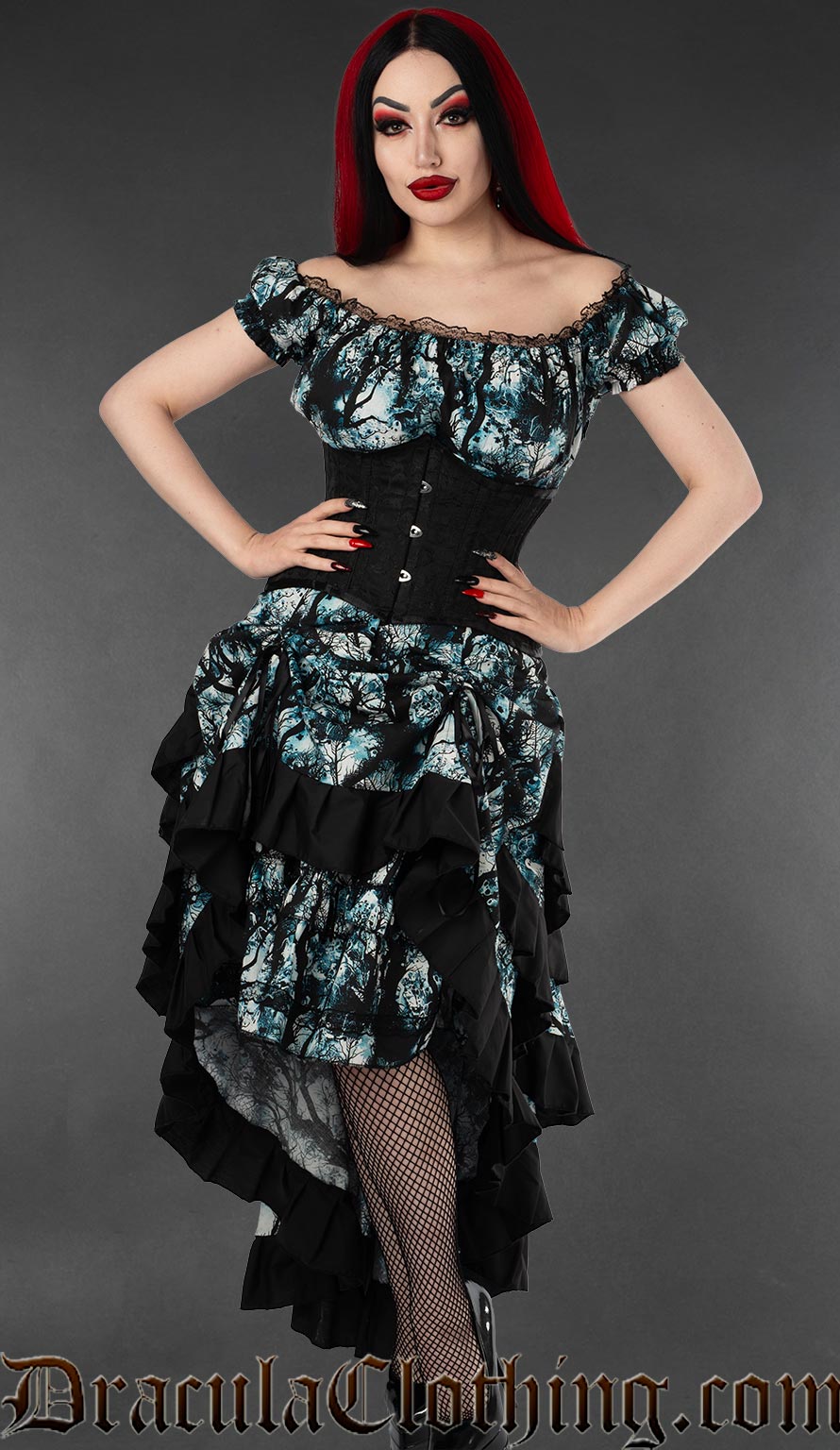Women's layered bustle skirt with a blue black and white cotton print of a full moon in a forest shown with the skirt lifted in the front and worn with a waist cincher and matching dress