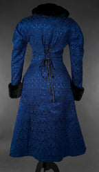 Blue gothic brocade coat with black faux fur collar and cuffs, back view on mannequin