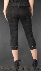 Back view of women's slim fit black brocade capris with silver stud details