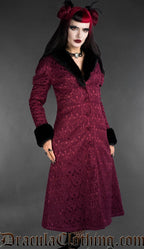 Front view of burgundy gothic brocade coat with black faux fur trim worn by a model on a gray background