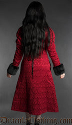 Woman modeling a red brocade gothic coat with black faux fur collar and cuffs, rear view
