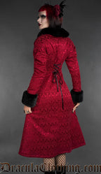 Woman wearing a red gothic brocade coat with black faux fur collar and cuffs, back view with lace-up detail