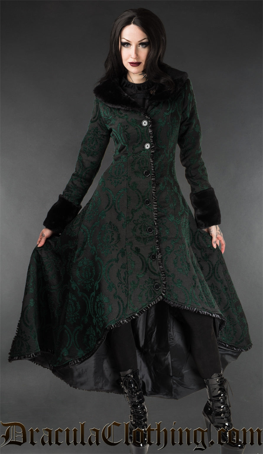Women's high low winter coat made with black and green brocade jacquard in a damask pattern with black faux fur accents