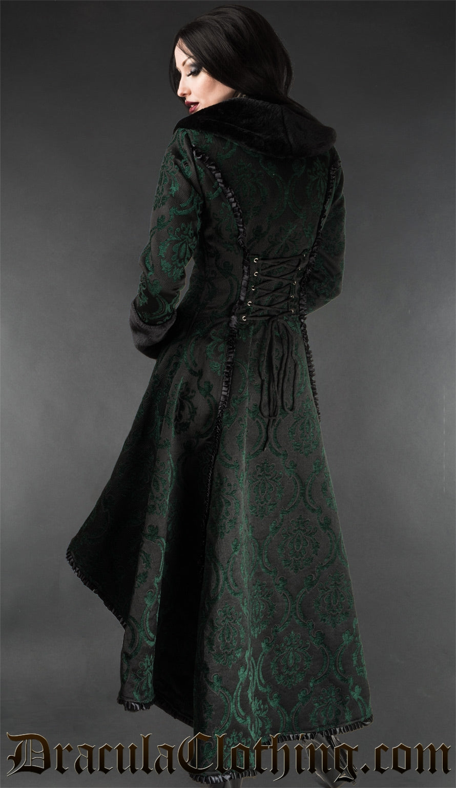 Back view of women's green and black brocade coat showing adjustable corset style lacing in the torso satin trim details and faux fur accent collar