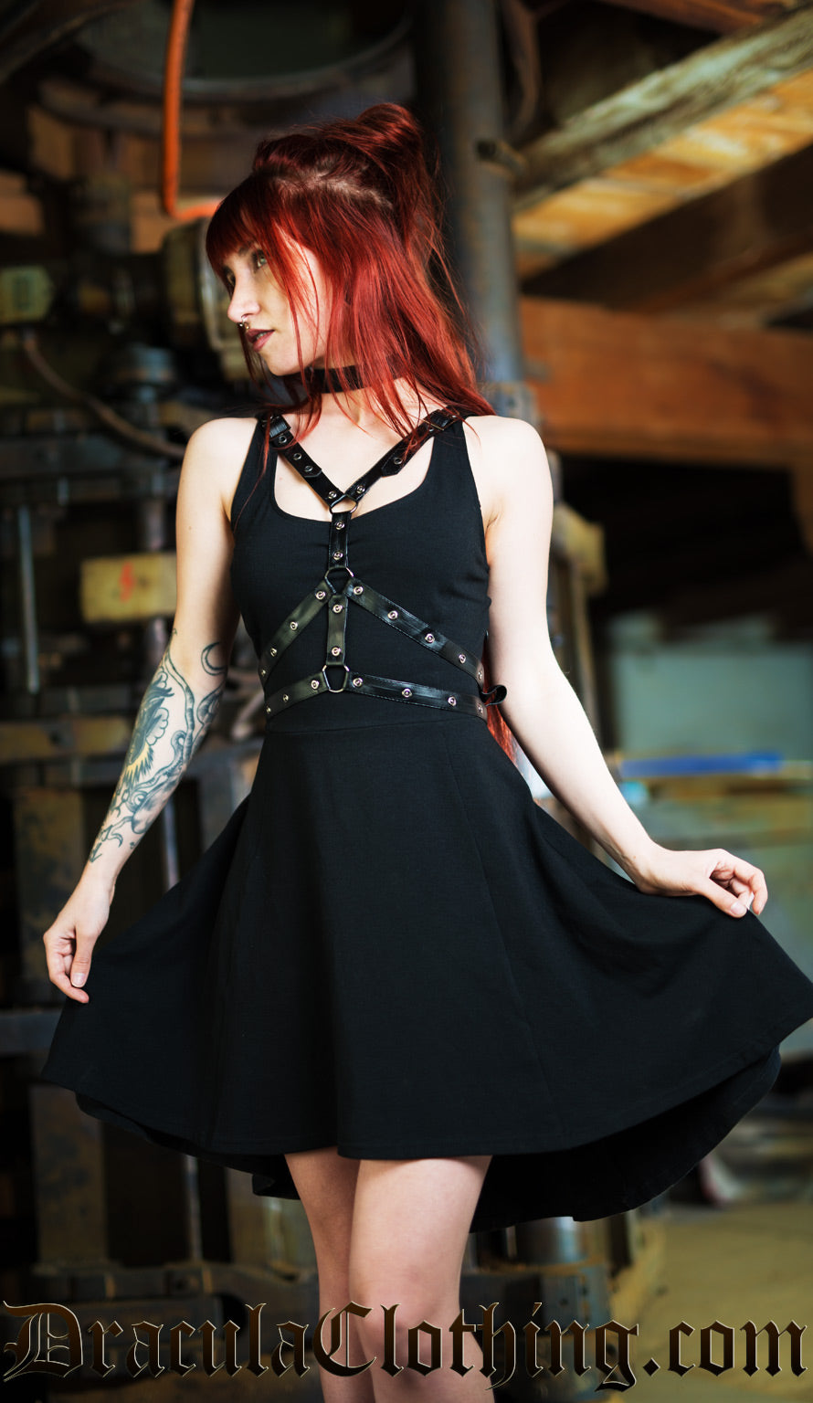 Model wearing black cotton over knee dress with detachable faux leather harness