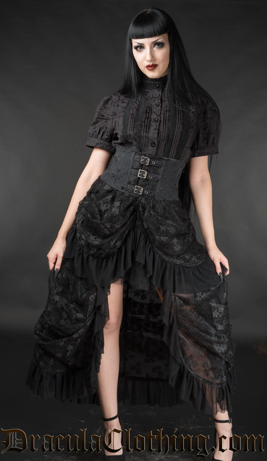 Model wearing women's high waisted black bustle skirt made with lace and mesh layers and adjustable buckles in the waist