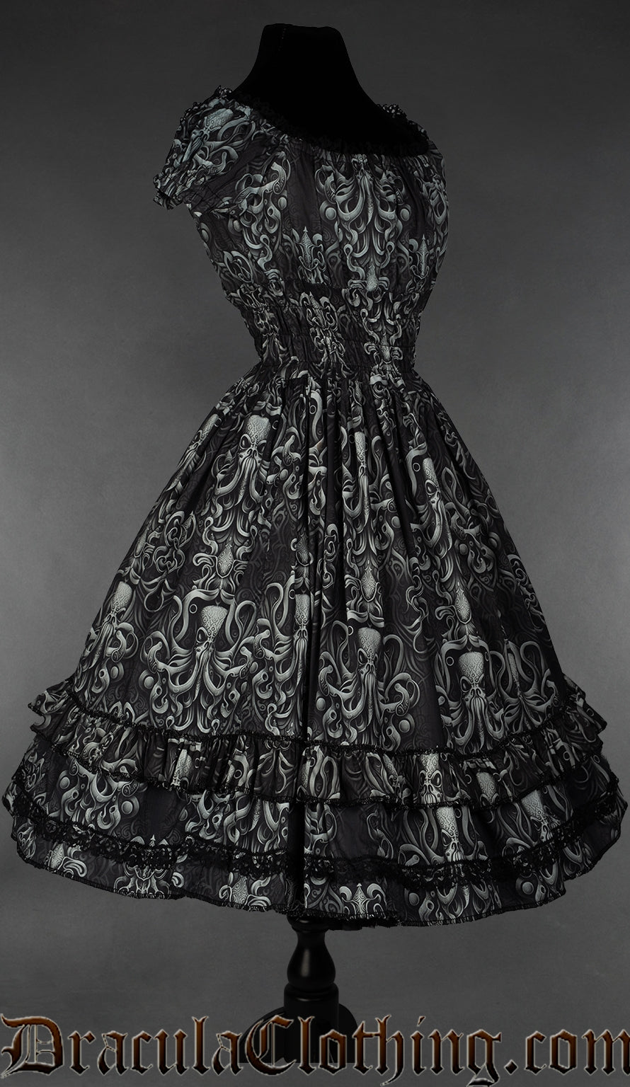 Side view of grey kraken inspired print on black women's dress showing elasticated waist and sleeves