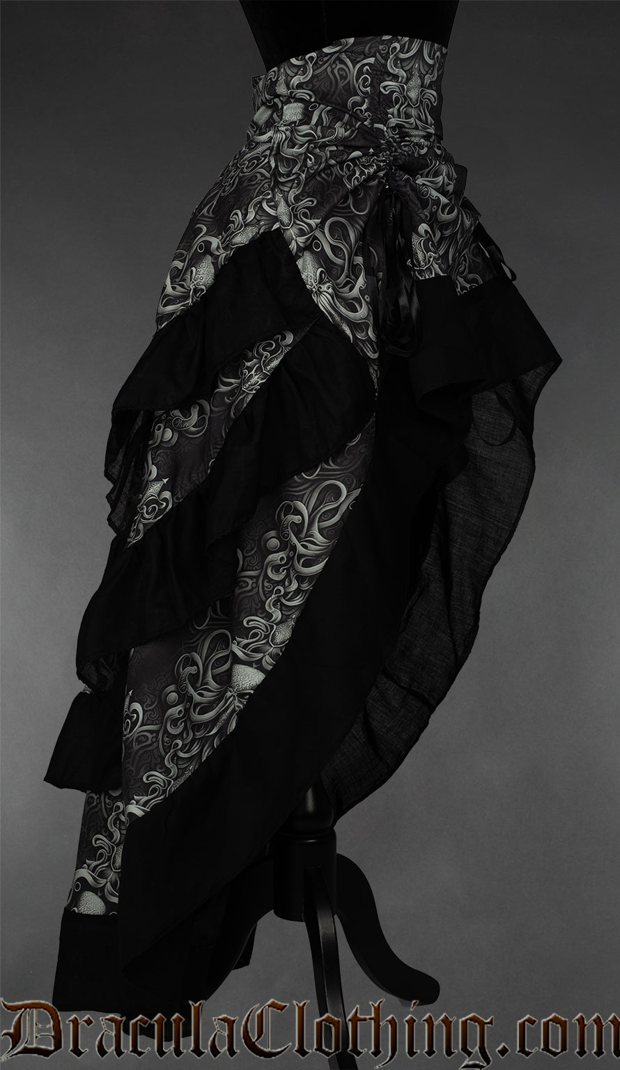 Side view of grey and black women's bustle skirt with kraken inspired print and black accents on the hem of each layer