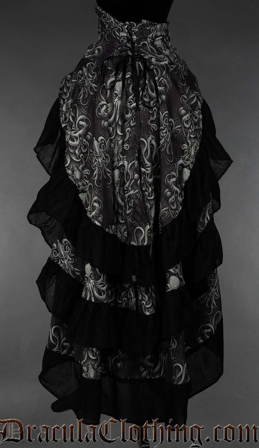 Back view of women's grayscale kraken print bustle skirt showing adjustable lacing in the waist and black cotton hem accents on three tiered layers