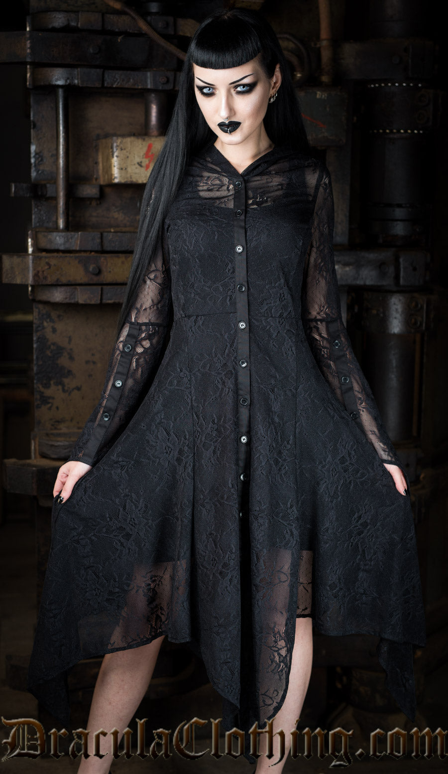 Women's long black lace overdress with handkerchief hem worn over another black dress by model
