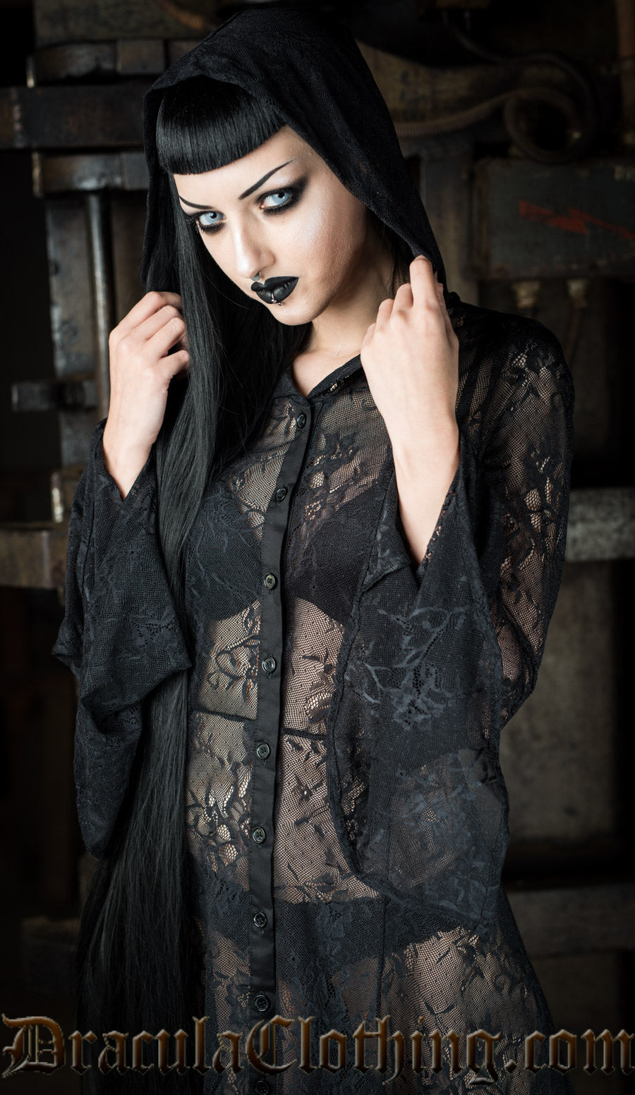 Close up of model showing hood and flared trumpet sleeves of the black lace overdress