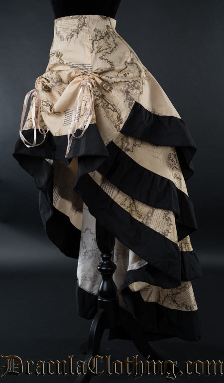 Beige women's skirt with printed map design and black cotton accents on the hem of each layer shown from the side with the front raised with two strings
