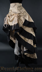 Beige women's skirt with printed map design and black cotton accents on the hem of each layer shown from the side with the front raised with two strings