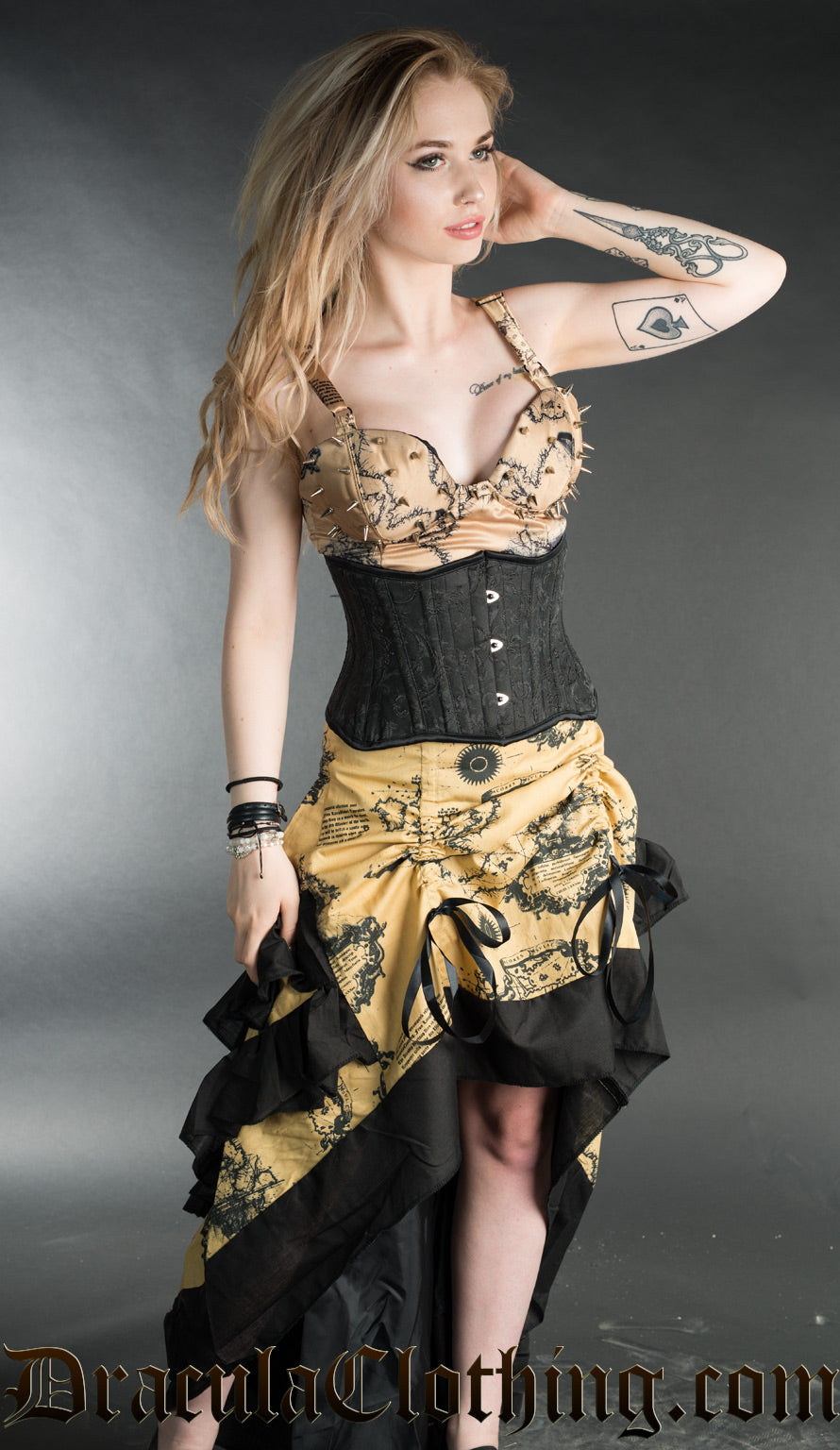 Model wearing map print spiked vest top with matching print bustle skirt and additional black waist cincher