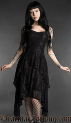 Woman wearing a black gothic mourning dress with lace material, fitted bodice and flowing layered handkerchief hem