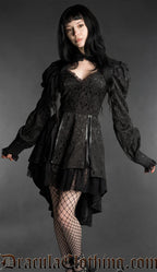 Woman wearing a black neo-Victorian brocade dress with sweetheart neckline, puff sleeves and high-low hem