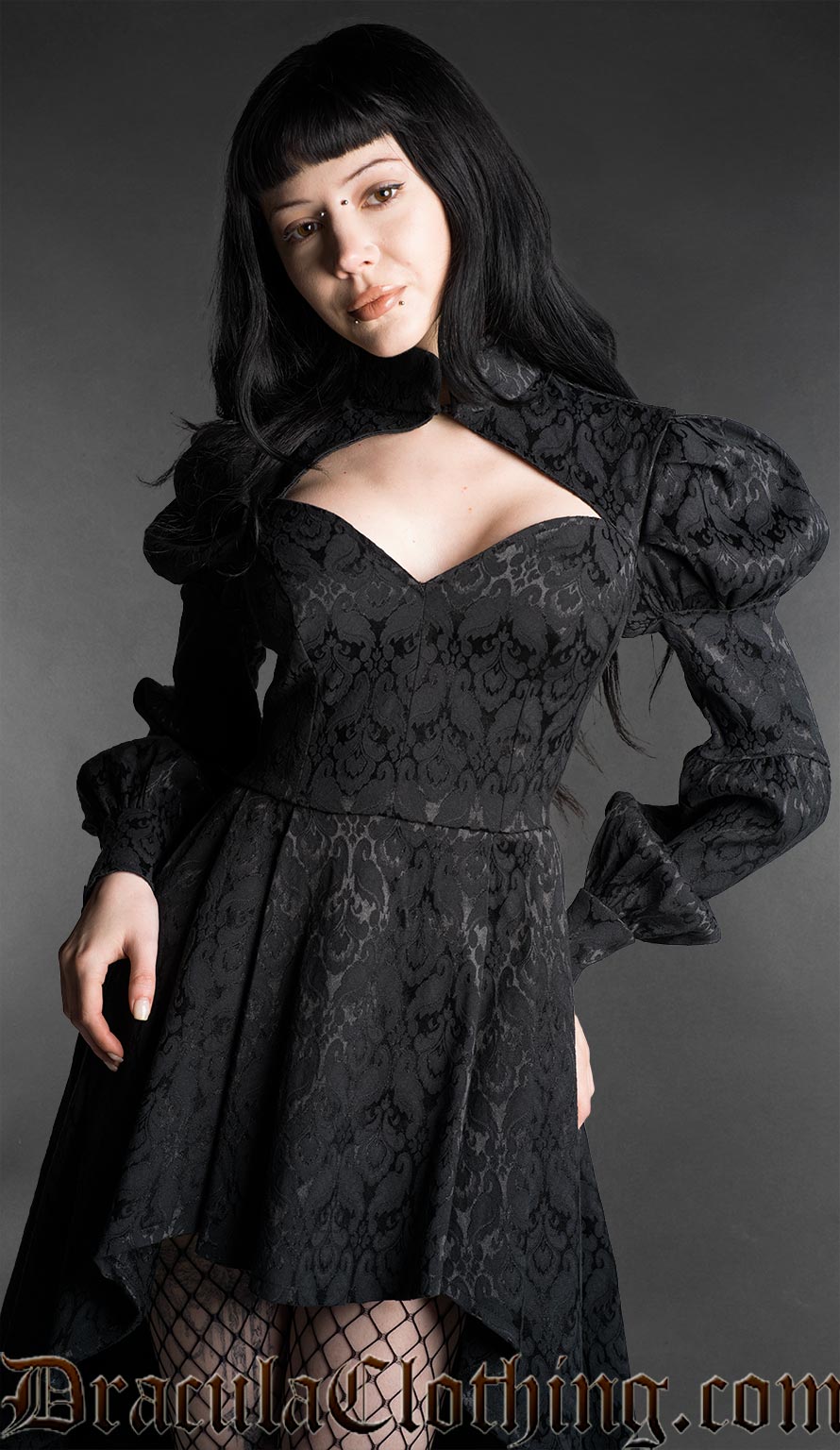 Woman wearing a black neo-Victorian high-low dress with floral brocade fabric, sweetheart neckline and puff bishop sleeves detailed view