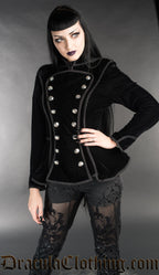 Model wearing black velvet women's military inspired jacket with button adorned front panel