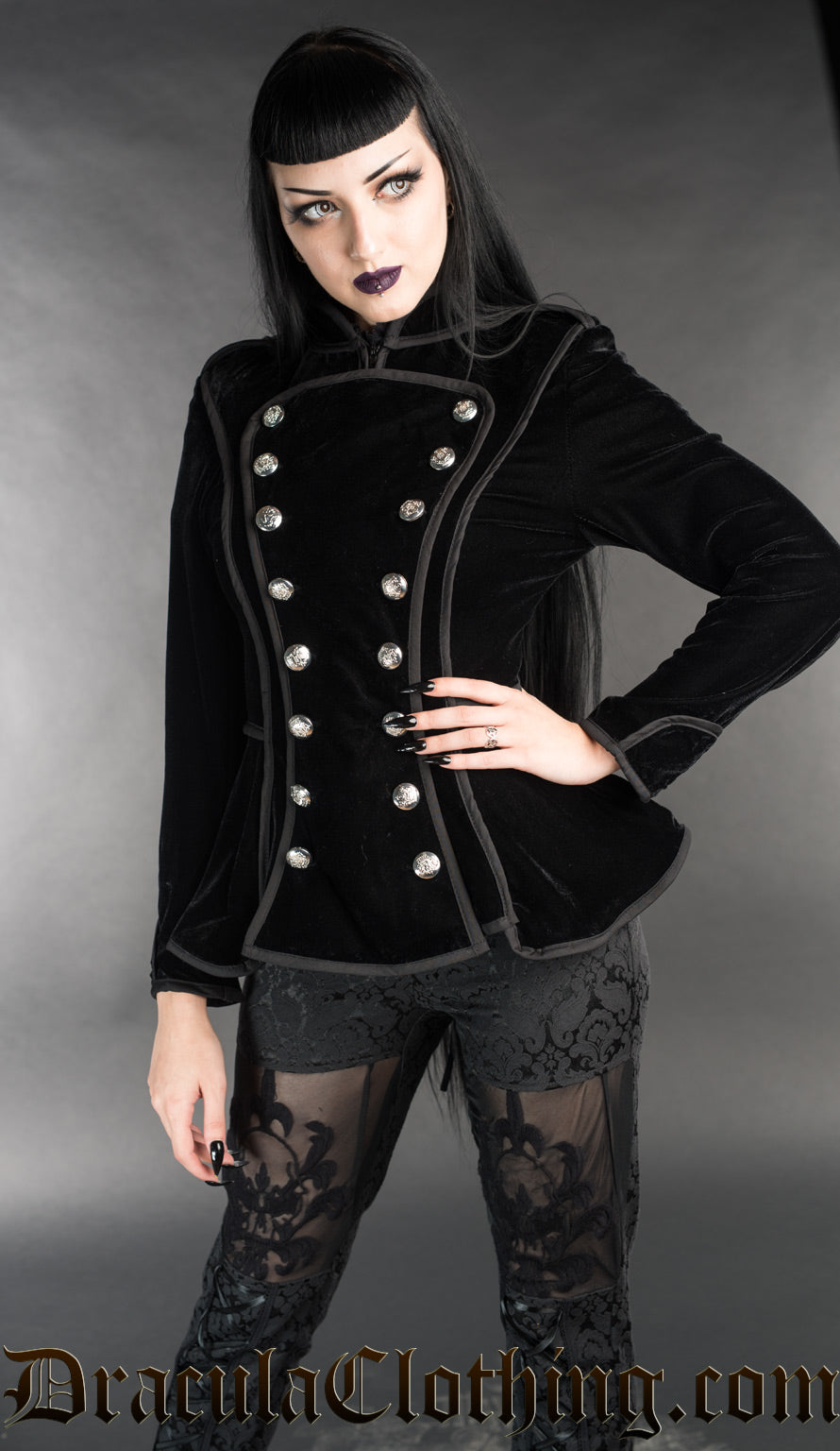 Model wearing black velvet women's military inspired jacket with button adorned front panel