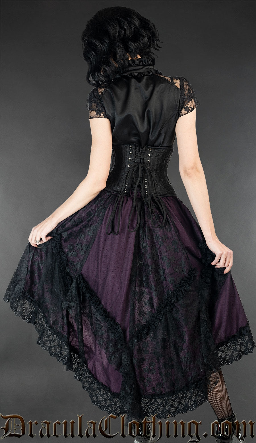 Back view of model wearing purple and black satin ruffle skirt showing lace trim and details