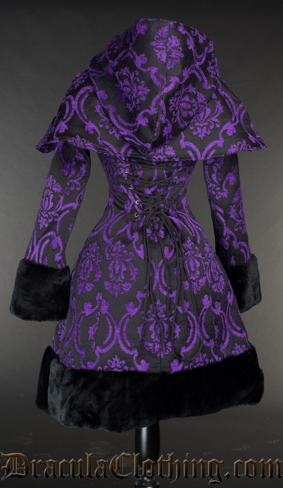 Back view of women's purple and black brocade winter coat showing adjustable corset style lacing in the torso and detachable hood and cape