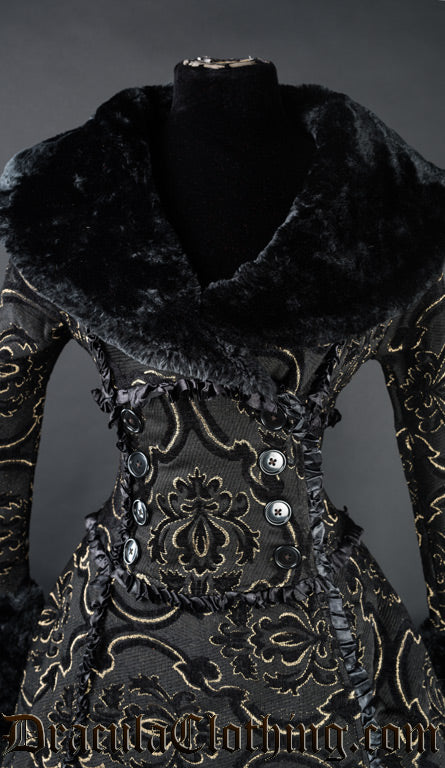 Close up of front of women's gold jacquard winter coat showing black faux fur collar wrap closure with decorative satin frills and buttons