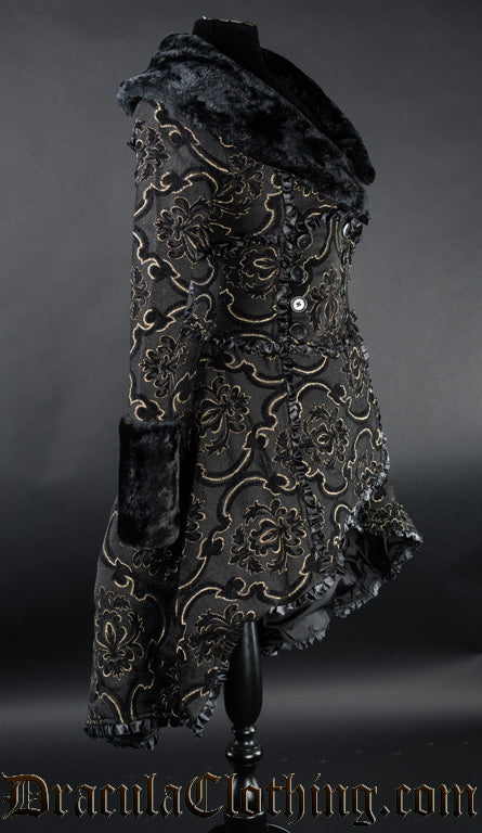 Side view of black and gold thick brocade women's coat showing high low hem longer in the back than the front