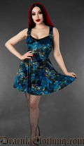 Model wearing a blue and black gothic velvet skater dress with raven print