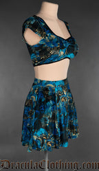 Side view of women's velvet short skirt with elasticated waistband in a blue and black raven and sheet music inspired print 