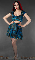 Short sleeved velvet women's crop top with raven and music print in multicoloured blue and black design shown on a model with matching print skirt