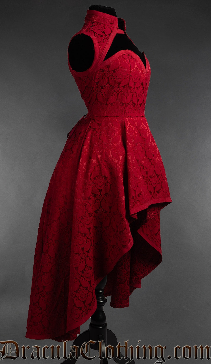 Side view of red brocade women's sleeveless choker dress showing the high low style skirt that's short in the front and longer in the back