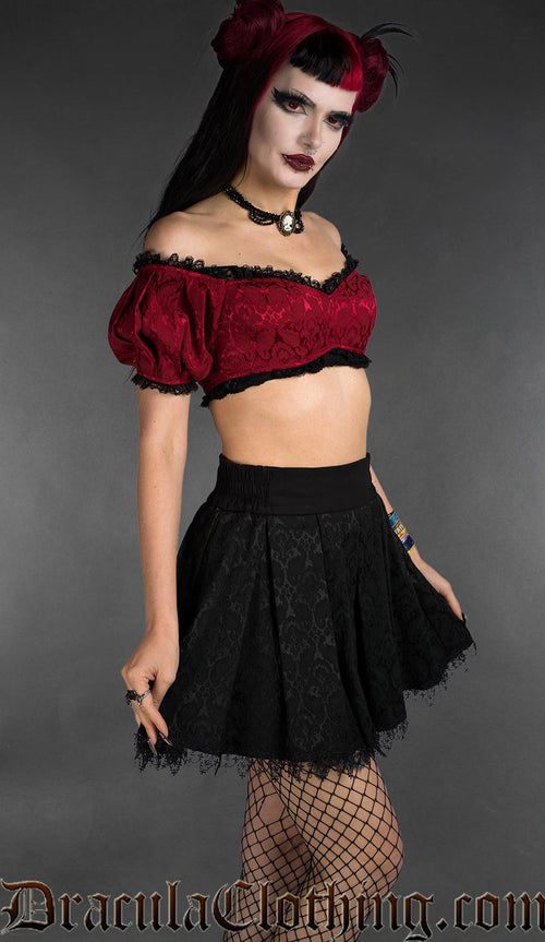 Red brocade gothic crop top with black lace trim, off-shoulder style, angled view on model