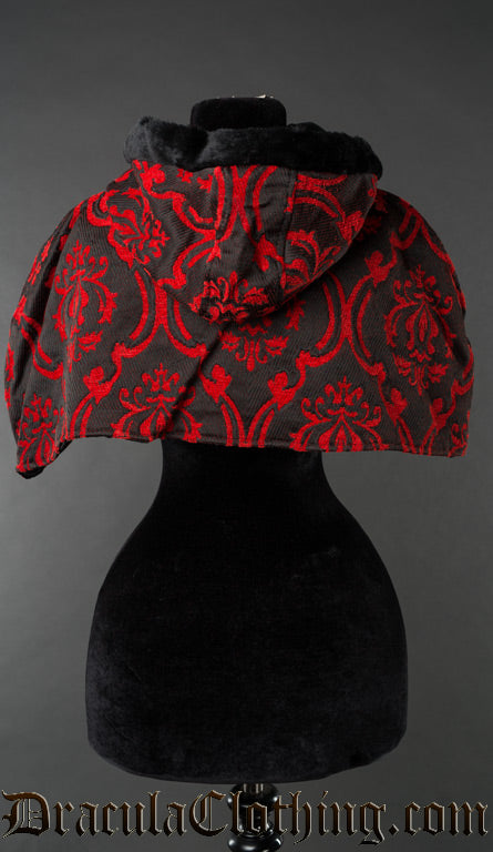 Back view of red and black brocade hood and cape showing faux fur trim on hood