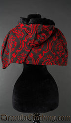Back view of red and black brocade hood and cape showing faux fur trim on hood