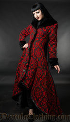 Model wearing black and red brocade women's winter coat with high low style button up front and black faux fur accents