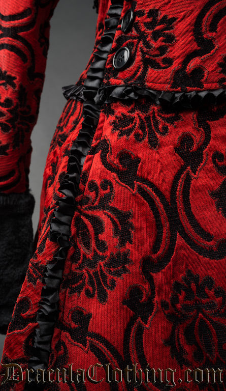 Close up of red and black women's coat showing brocade fabric in damask pattern and ruffled satin trim details