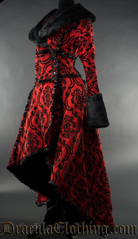 Side view of women's red and black brocade winter coat with faux fur accents showing high low style hem