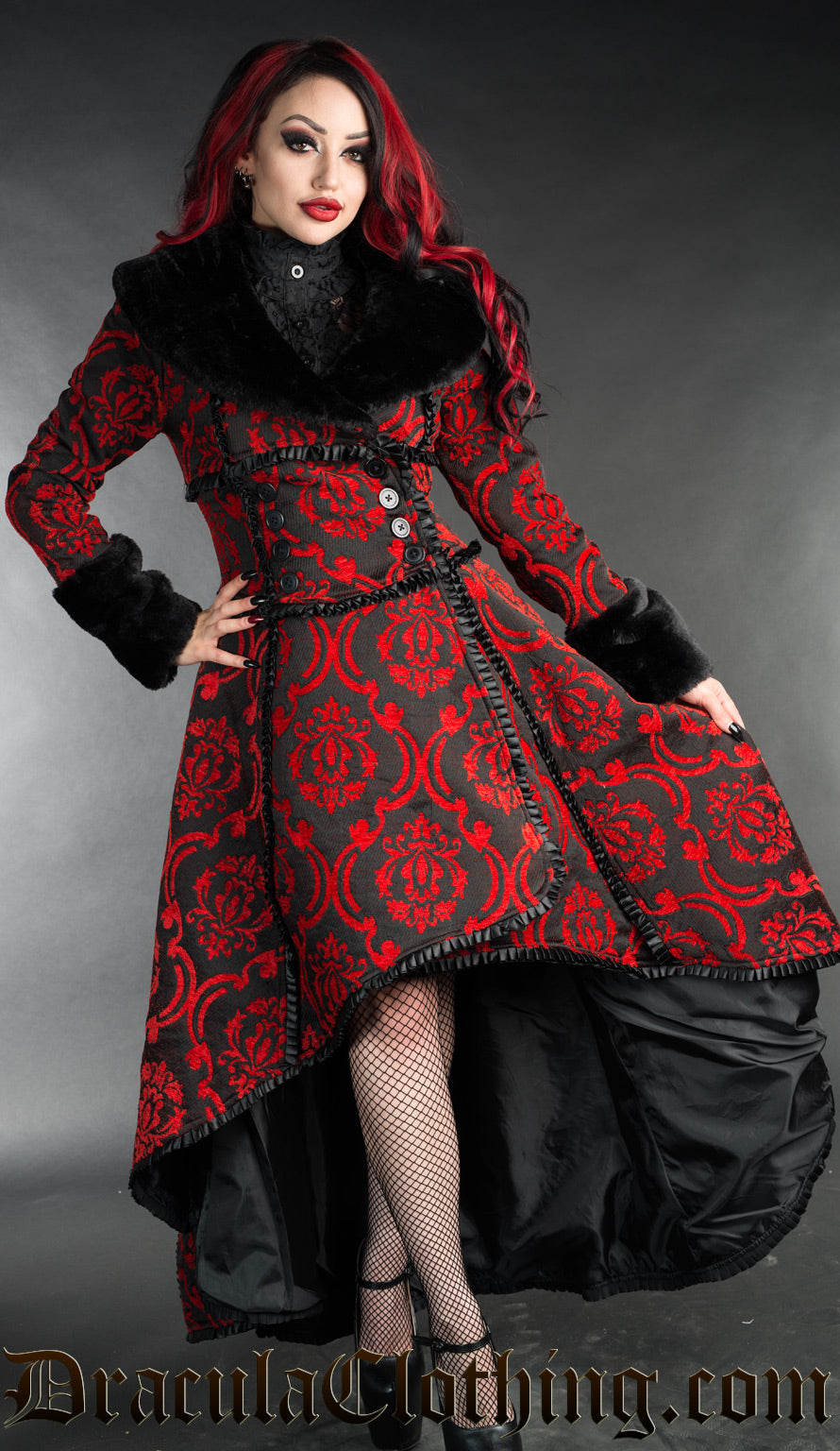 Women's high low coat in a wrap around style made with red and black thick brocade fabric in a damask pattern and faux fur accents