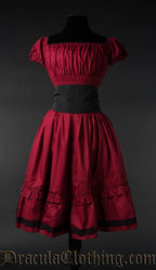 Red cotton women's knee length dress with elasticated bust and sleeves shown with black belt 