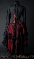 Back view of red and black lace and satin women's ruffle skirt alongside other clothes showing longer skirt length in the back