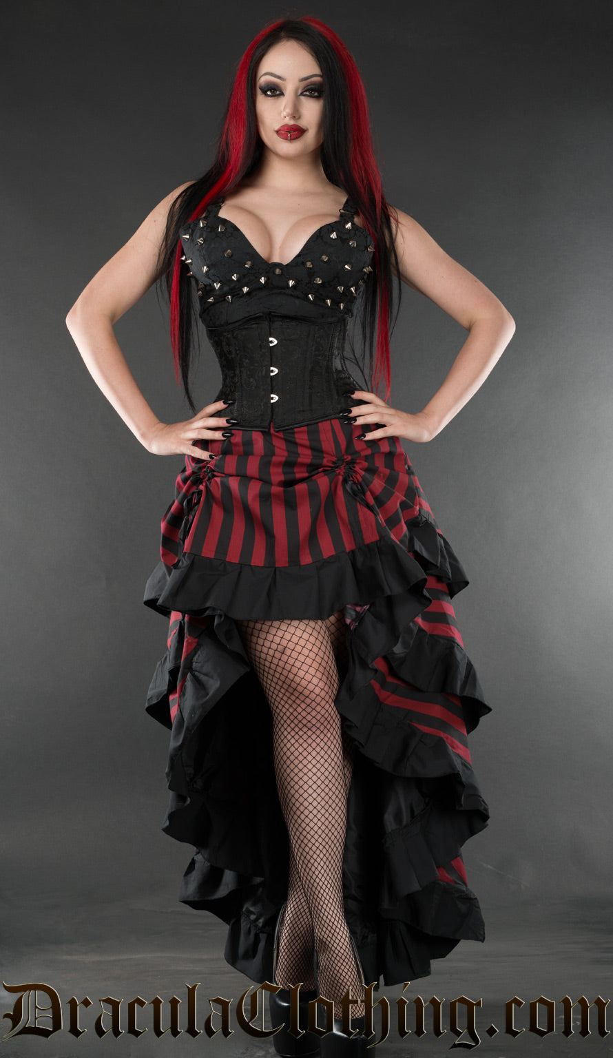 Women's bustle skirt in red and black vertical stripes with black cotton hem accents and shown with the front raised above the knee
