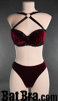 Women's red velvet bra with black lace trim and crossed straps with o-ring in the centre