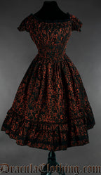 Women's knee length dress with elasticated waist bust and sleeves made using black and red brocade fabric