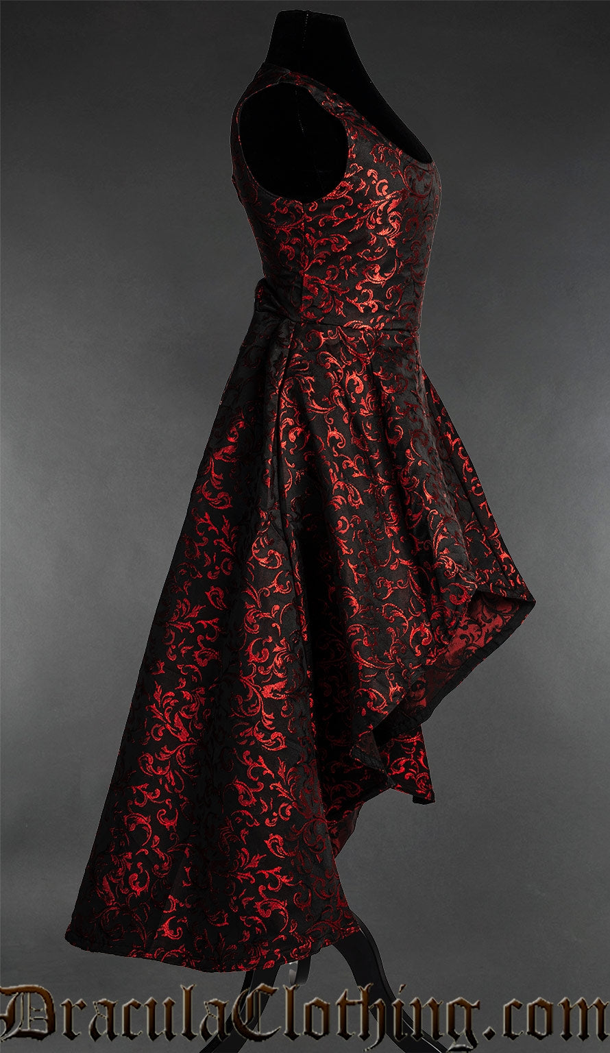 Side view of women's sleeveless black dress with red woven brocade details and high low hem