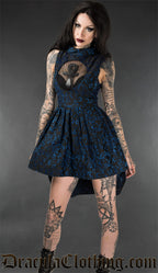 Model wearing blue brocade short high low dress with mesh illusion keyhole panel and ankh motif