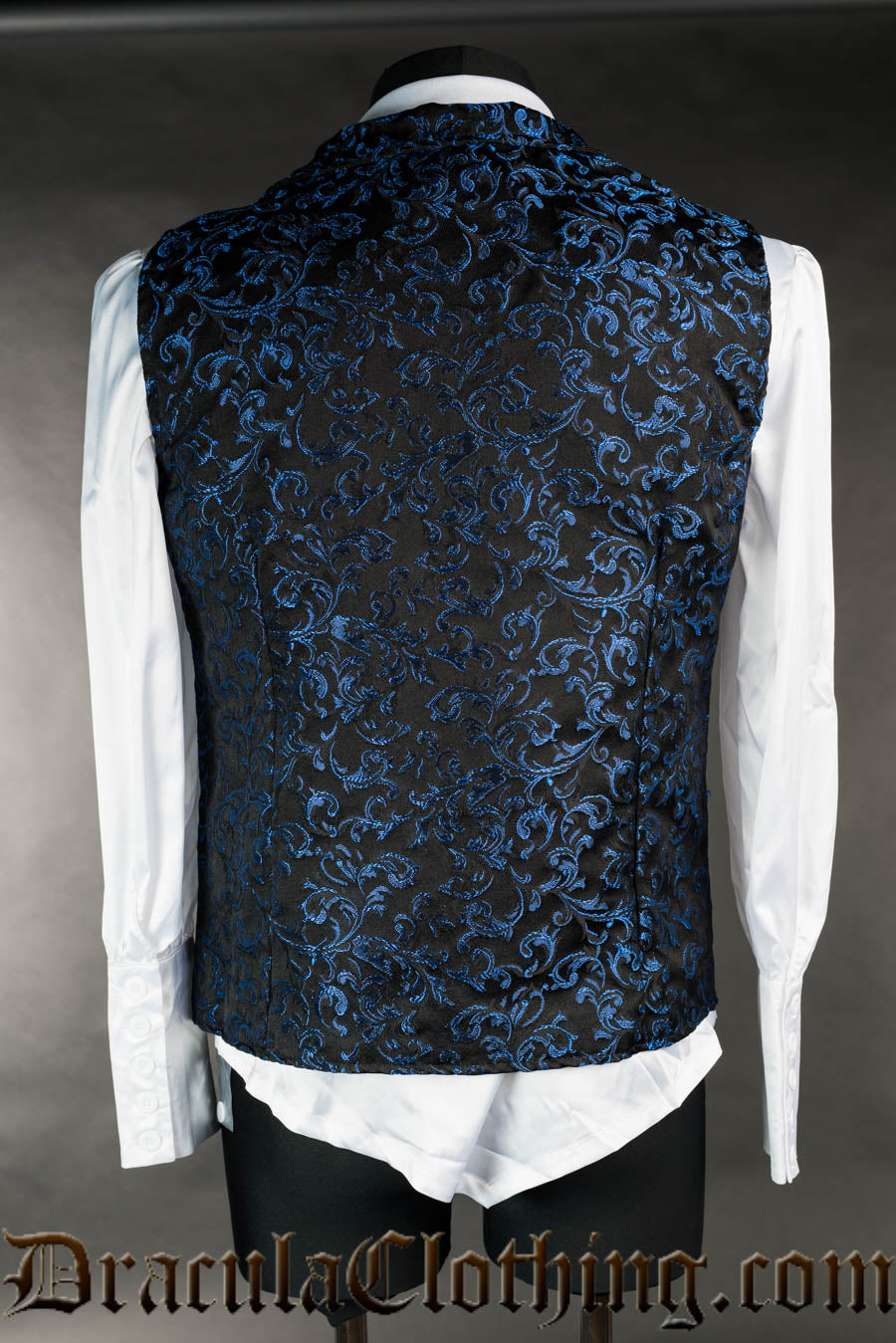 Back view of men's sapphire brocade blue vest worn over a white long sleeved shirt